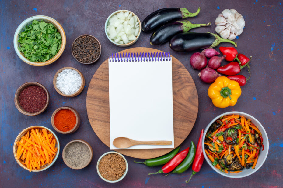 Aara Living seasonal Indian kitchen setup with fresh vegetables and spices arranged around a notepad